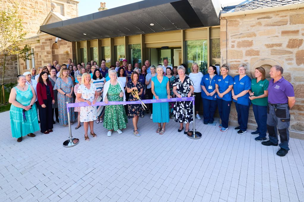 Tracy Flynn cuts the ribbon to officially open the building to the community